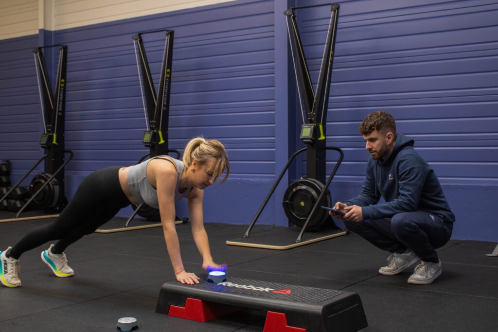 Robin qui regarde une adhérente faire du gainage dynamique