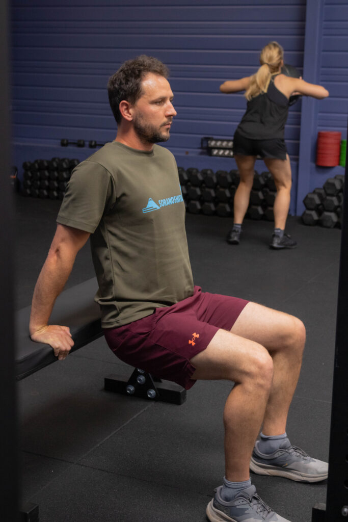 pratiquant à la salle qui fait des dits sur banc