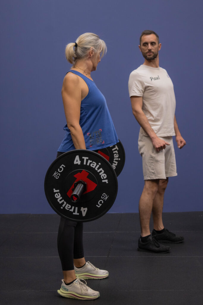 Paul coach une adhérente sur un deadlift