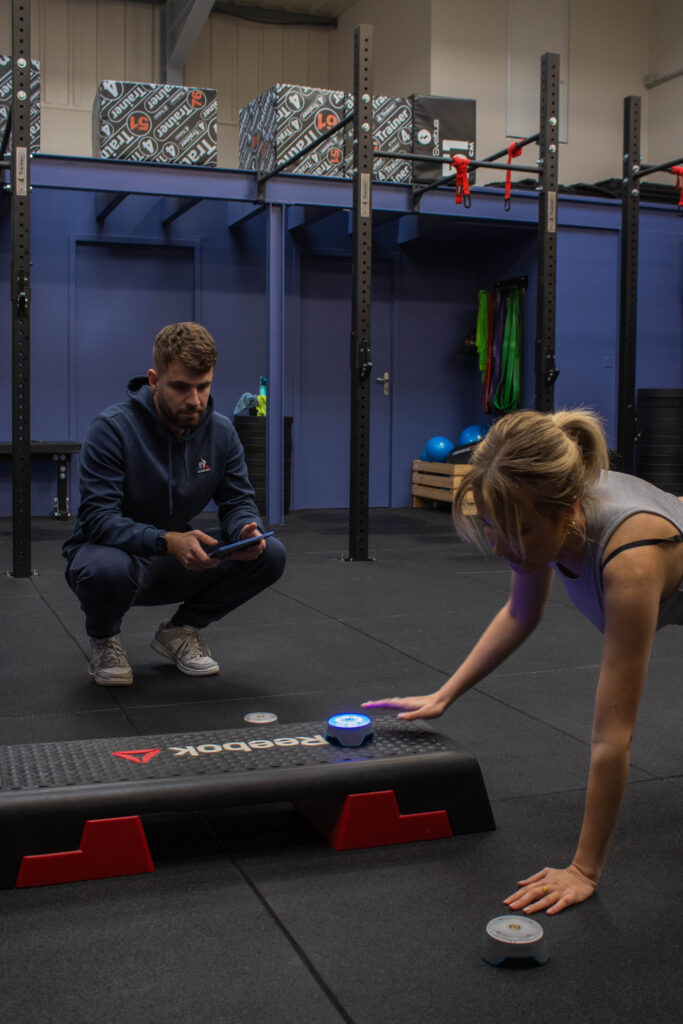 coach qui regarde son adhérent fait du gainage